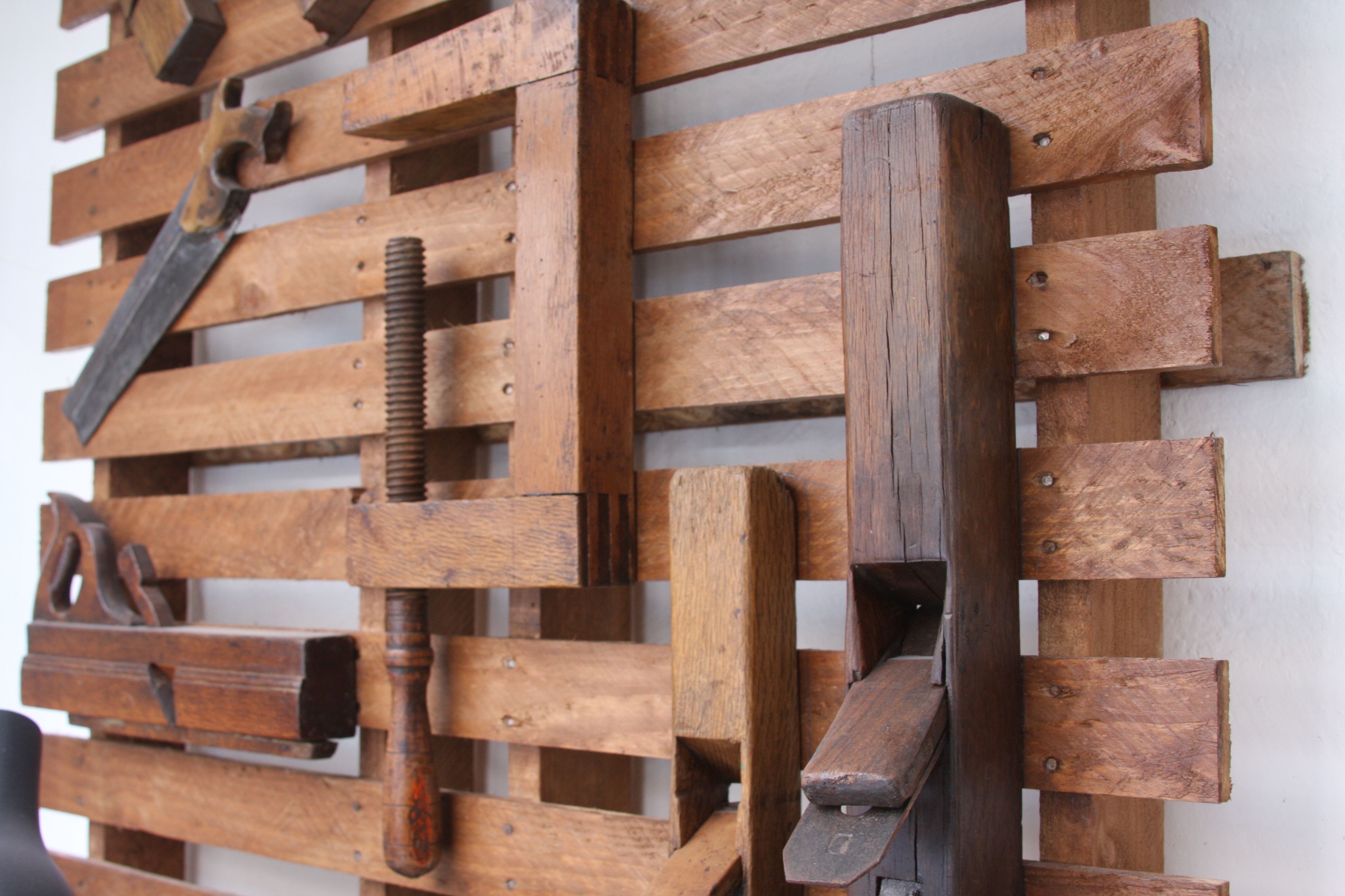 Herramientas manuales de carpintería colgadas en listones de madera