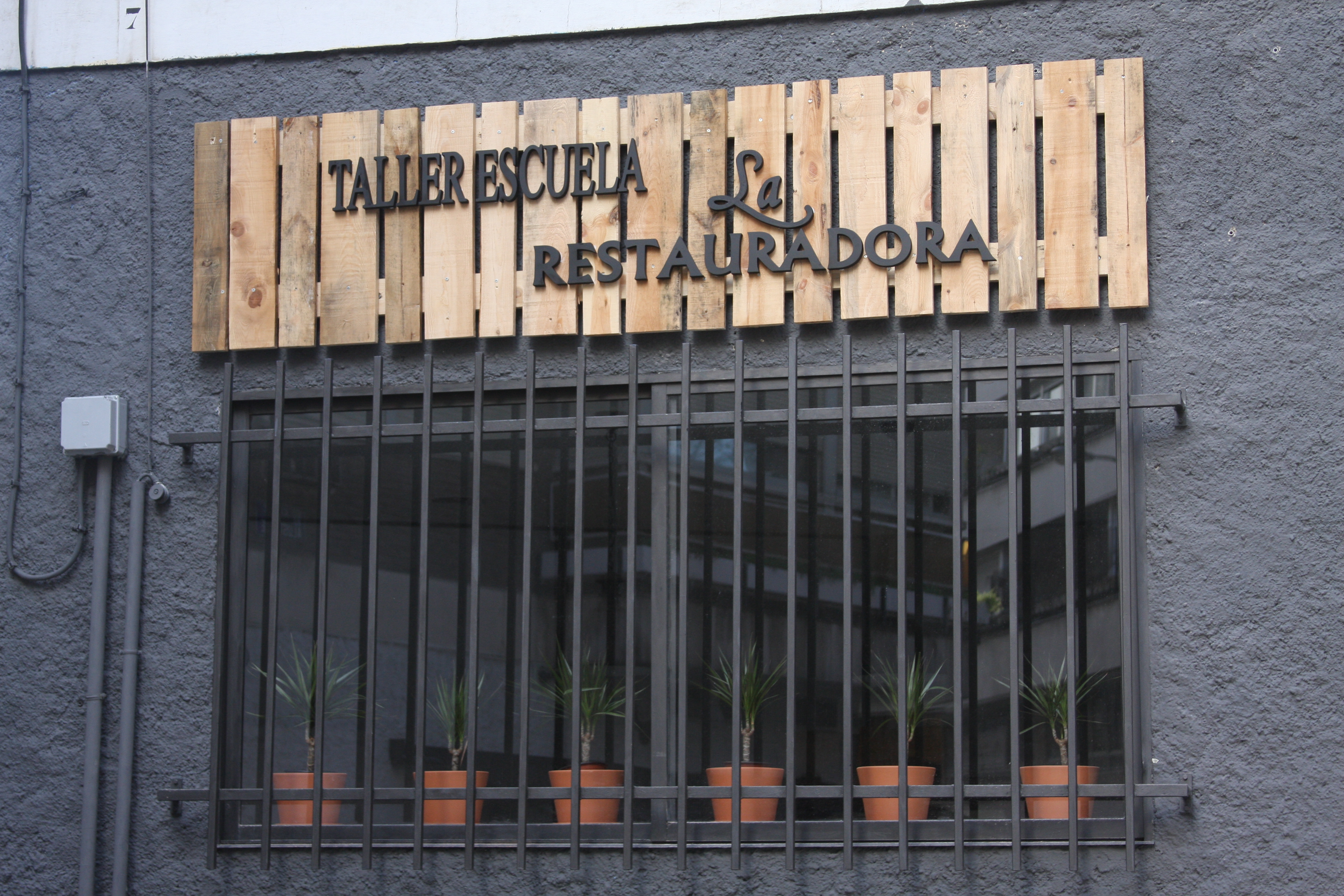 Fachada del taller con el letrero de Taller Escuela La Restauradora